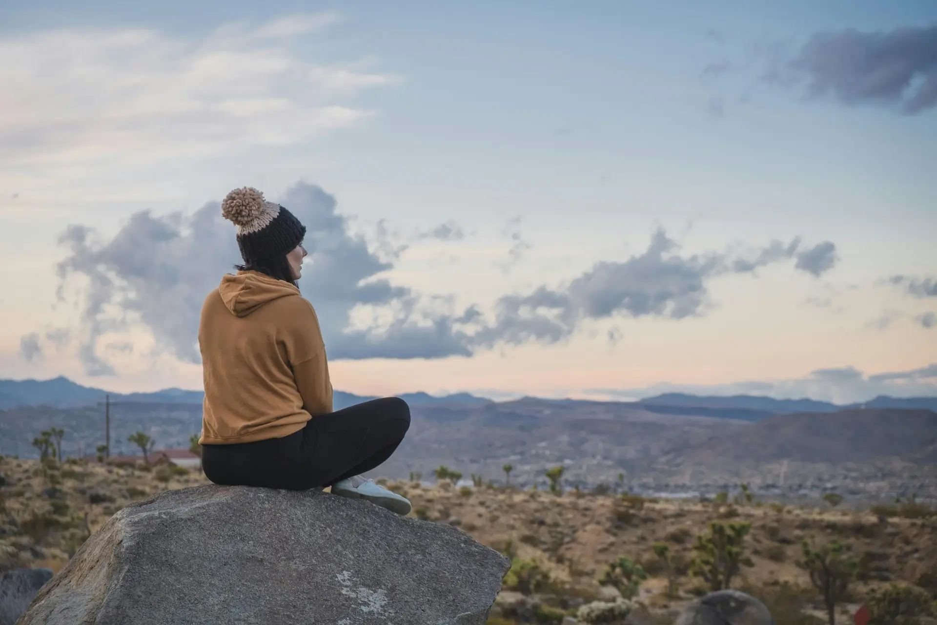 A person sitting on a rock enjoying the scenic desert view